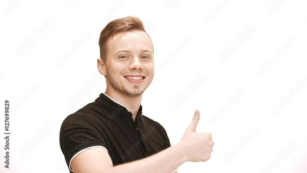 Young handsome man smiling, showing okay over white background. Slow motion. Young handsome man smiling, showing okay over white background. Slow motion.