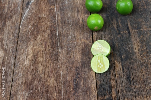 lemon fresh green and slice lime on wooden table, top view