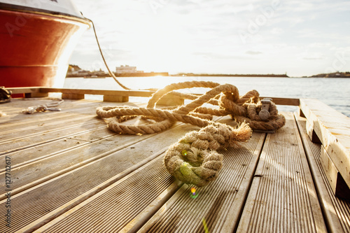 wooden pier rope, moored fishing boat