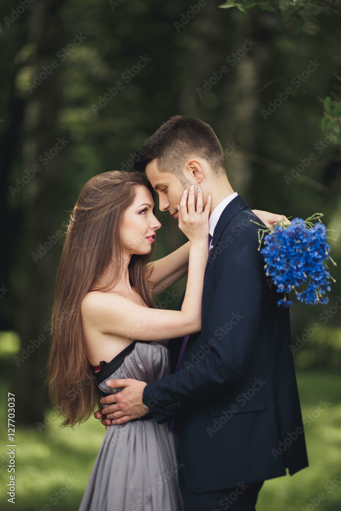 Fototapeta premium Young beautiful couple, girl with perfect dress posing in park