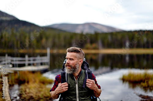 Hiker with lake in background, Kesankijarvi, Lapland, Finland photo