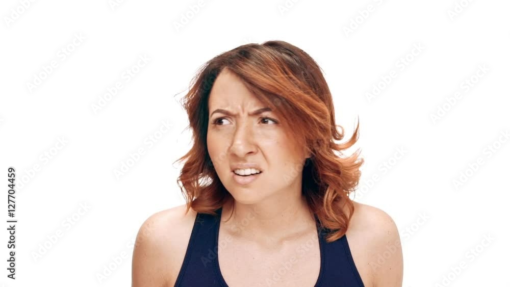 Displeased young beautiful girl over white background. Slow motion. Displeased young beautiful girl over white background. Slow motion.