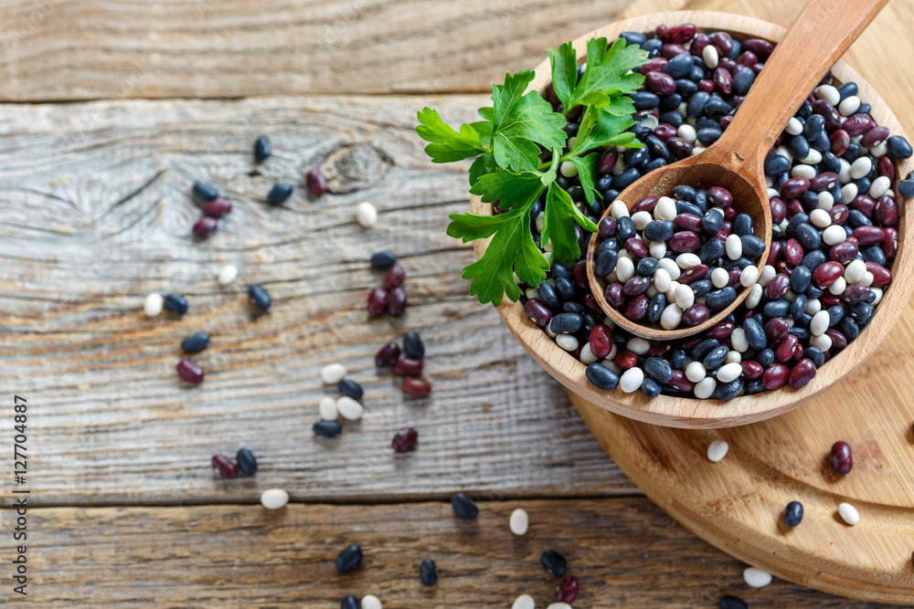 Wooden spoon in a bowl with a red, white and black beans. Wooden spoon in a bowl with a red, white and black beans.