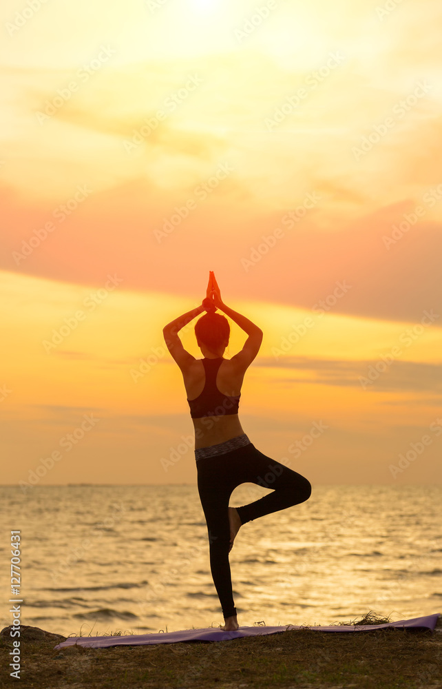 Silhouette yoga, Asia young woman practicing yoga on the beach and sport yoga.