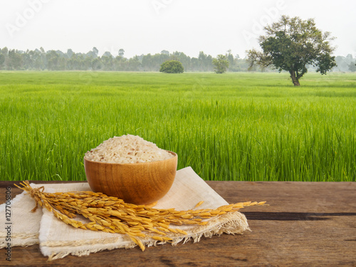 Jasmine rice in bowl and gloden spike on wooden table of morning