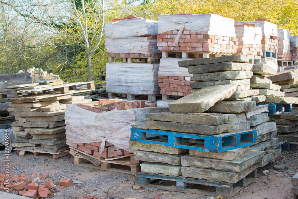 Reclamation yard background: stacks of paving slabs and reclaimed bricks on the pallets, selecive focus Reclamation yard background: stacks of paving slabs and reclaimed bricks on the pallets, selecive focus