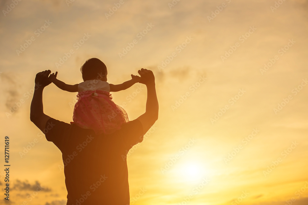 Father took the baby learn to walk at sunset.