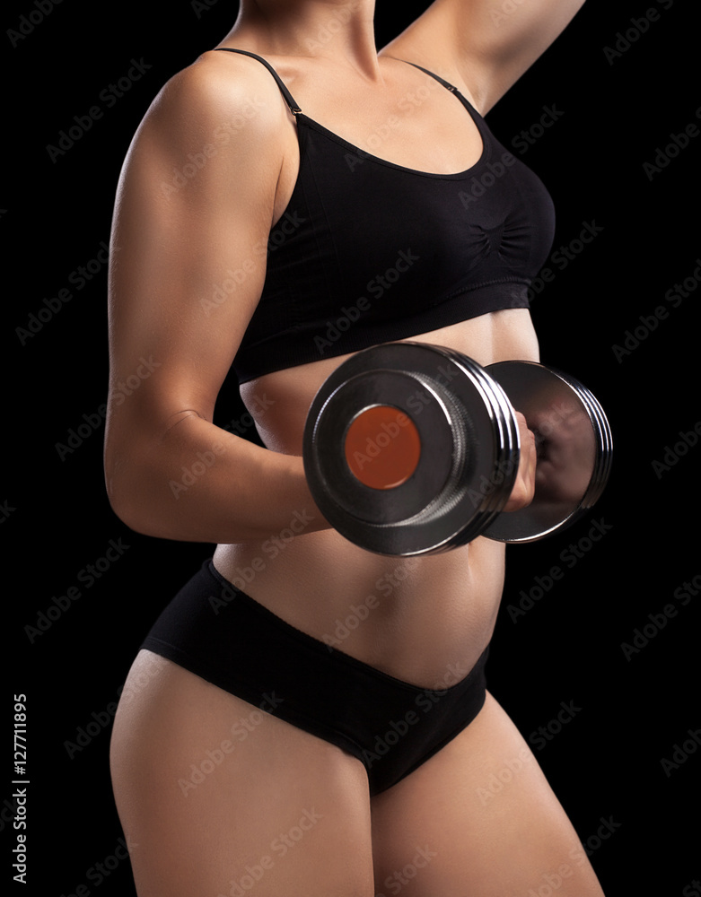Fototapeta premium Athletic girl with dumbbells in hand.