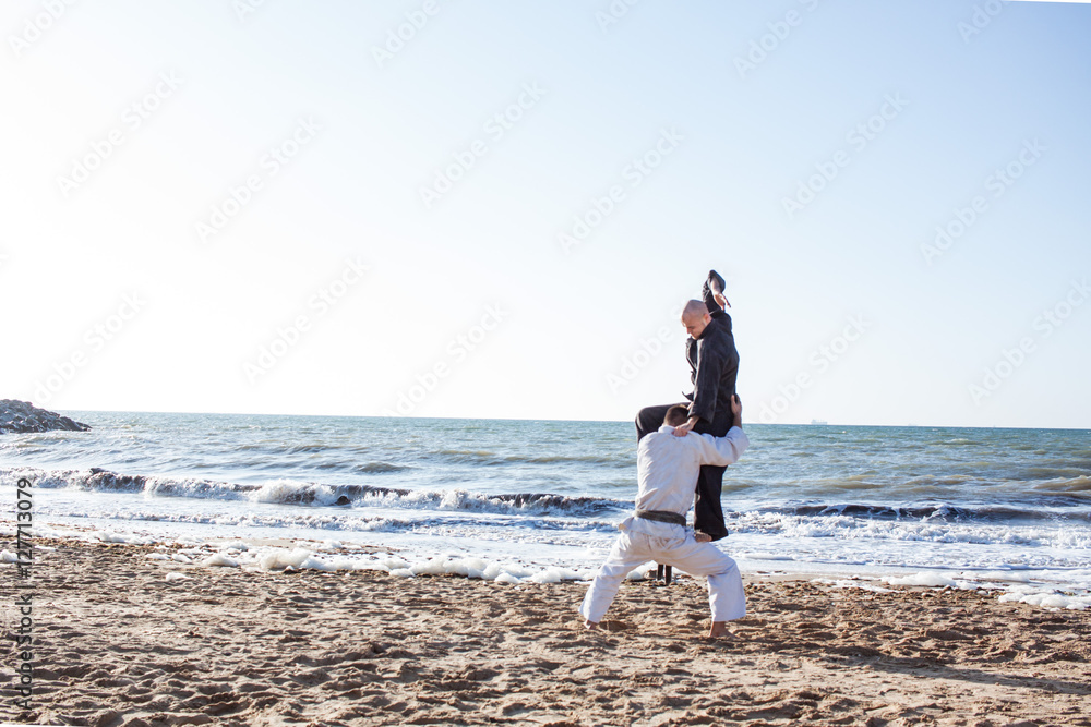 karate sparing on the beach sand sea background karate sparing on the beach sand sea background