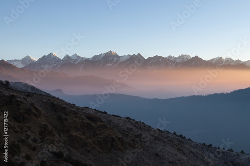 Misty mountain sunrise landscape in Himalayas, Nepal. Misty mountains scenery with high altitude peaks and Everest mountain on the background.