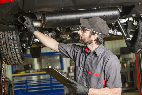 Mechanic working on car in his shop