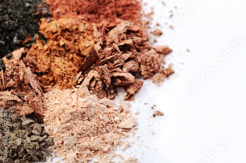 crumbled eyeshadow of different colors on a white background