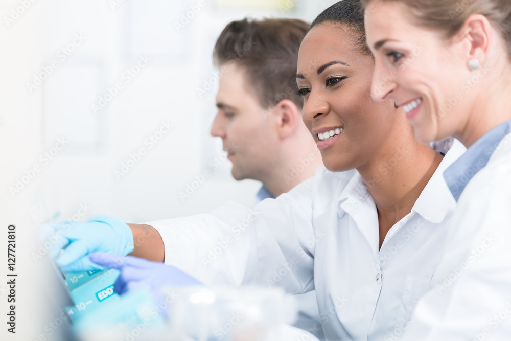 Group of researchers during work on devices in laboratory Group of researchers during work on devices in laboratory