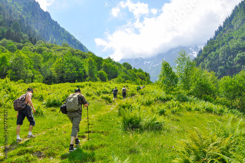 Young hikers trekking in alps, Switzerland, with mountains in the background