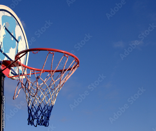Basketball basket hoop and backboard isolated against blue sky