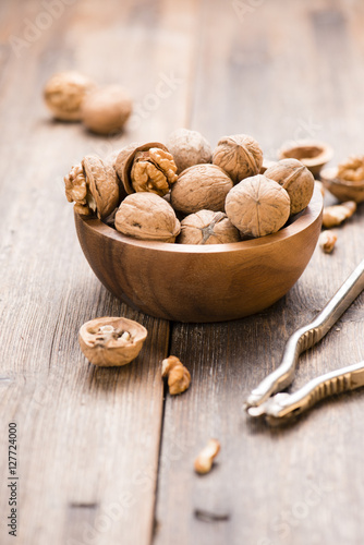 Walnuts in wooden bowl on table with Nutcracker.