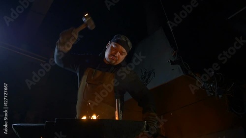 Blacksmith hammer strikes. Slow motion