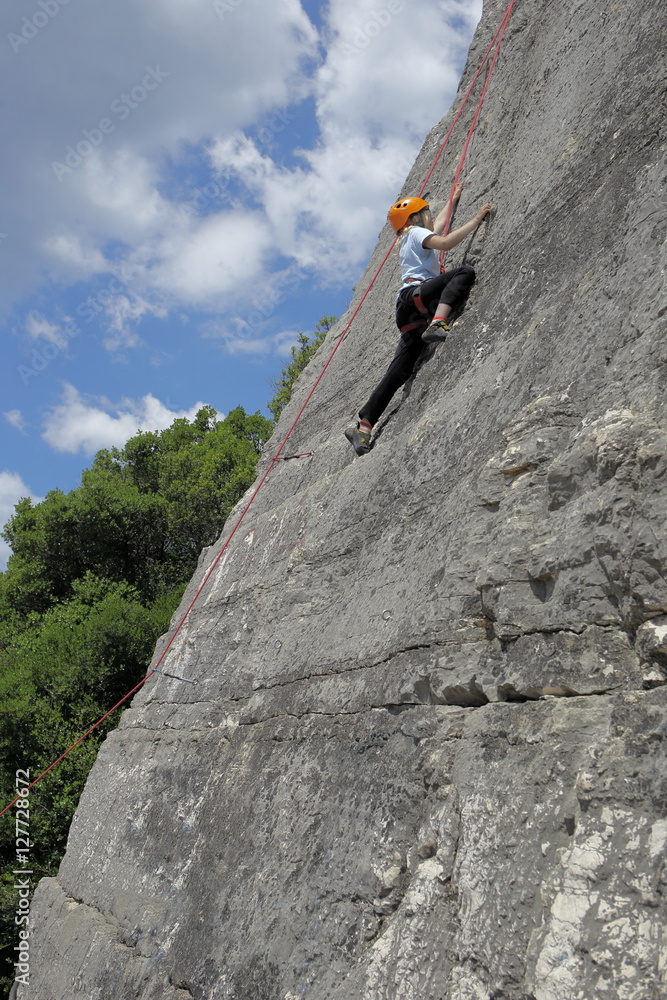 Mädchen klettert an Kalksteinmauer Mädchen klettert an Kalksteinmauer