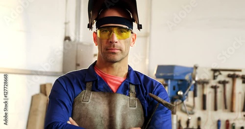 Portrait of male welder standing with arms crossed