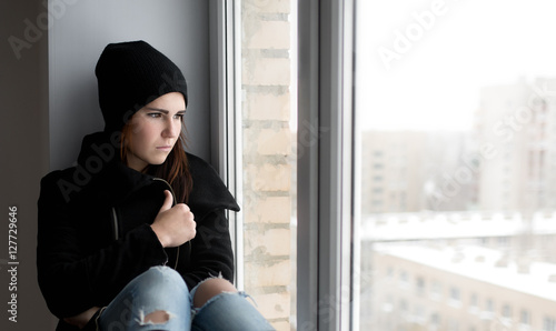 Girl looking through window