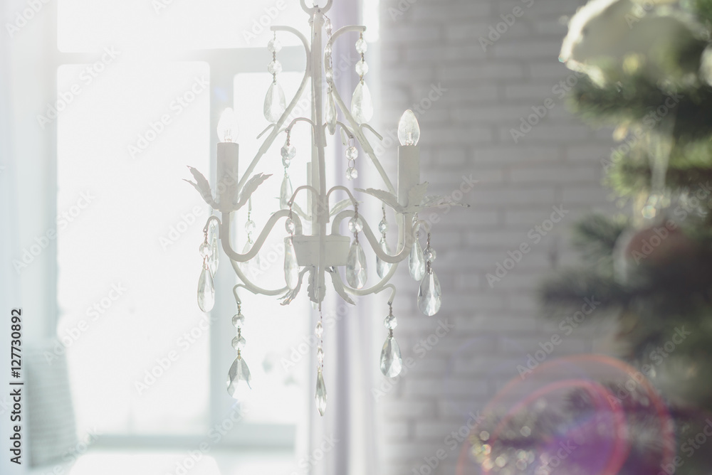 White chandelier in the living room with Christmas tree