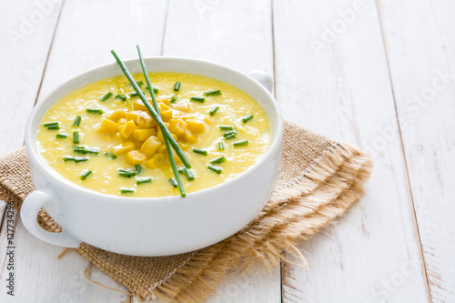 Corn soup in white bowl on white wooden background.copyspace
