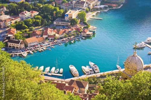 Bay of Kotor in Montenegro with view of mountains, boats and old houses with red tile roofs 