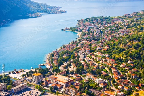 Bay of Kotor in Montenegro with view of mountains, boats and old houses with red tile roofs 