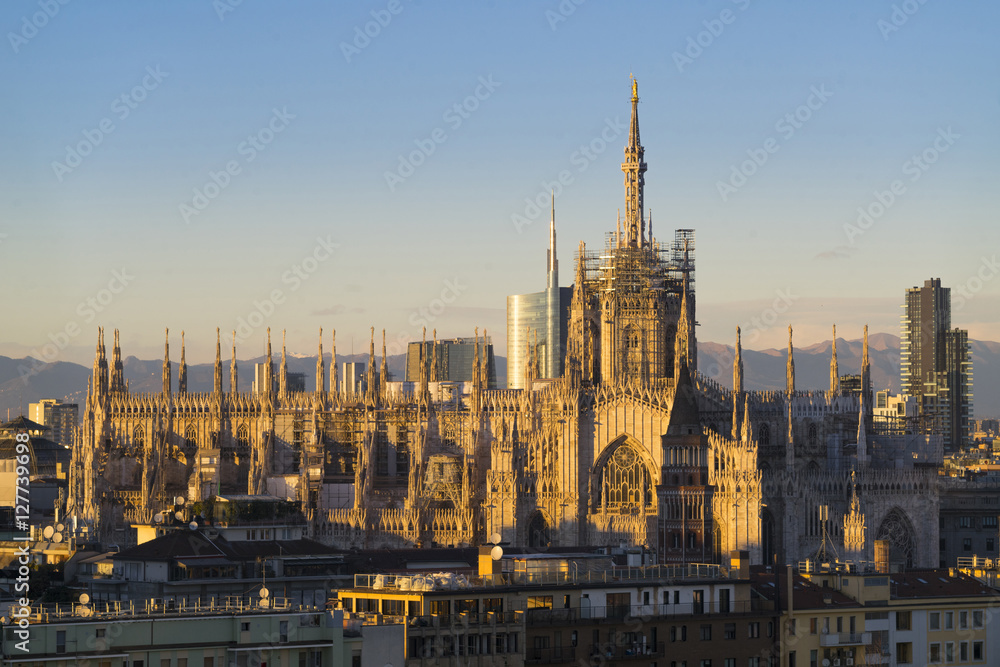 Duomo di Milano with Milan Skyline and alps on background at daw
