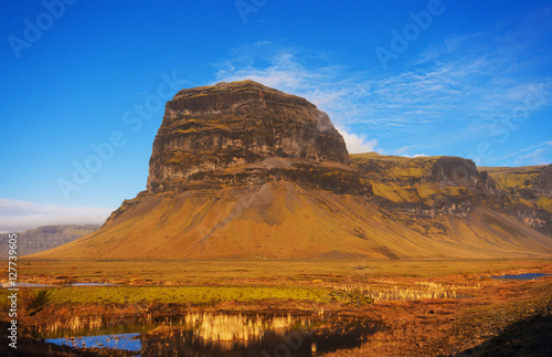 Lomagnupur Mountain, a precipitous promontory on the south coast of Iceland.Amazing Icelandic landscape with water mirror. photo