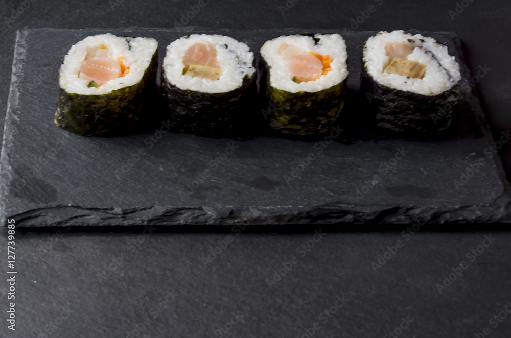 Pieces of sushi on a black stone Pieces of sushi on a black stone