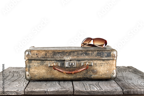 Vintage suitcase with sun glasses on wooden table