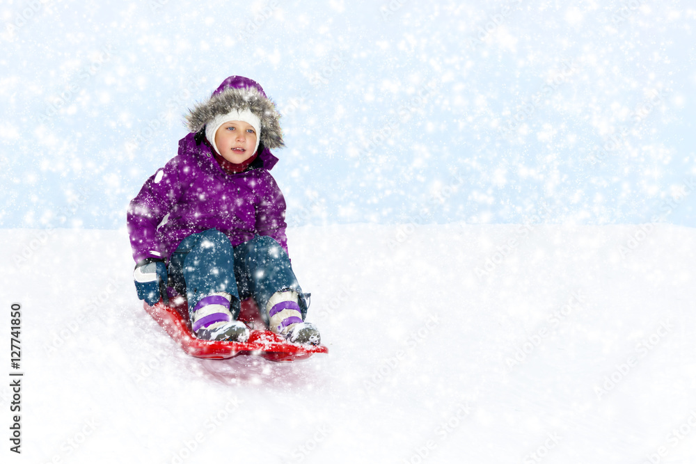 Little girl sliding in the snow.