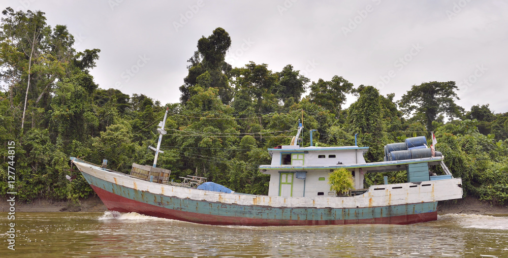 Indonesian traditional merchant ship on the river. New Guinea Island.