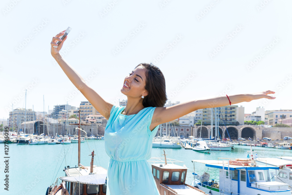 Lovely happy smiling tourist girl taking self-portrait picture u