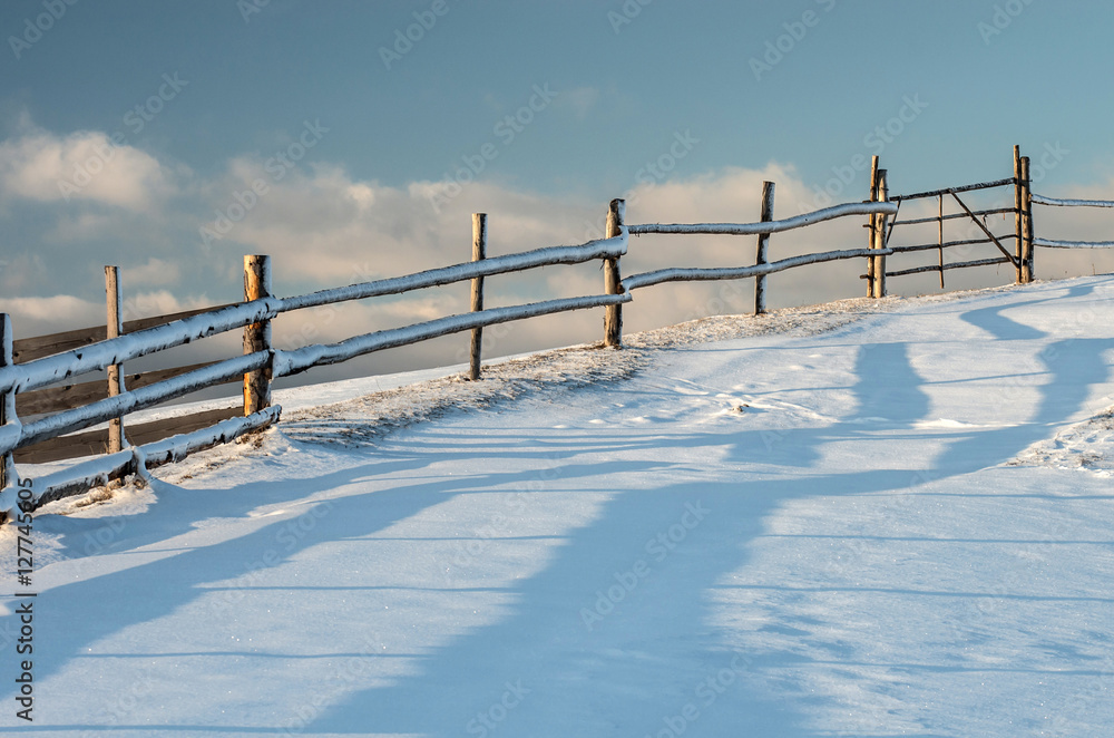 Fence pastures on a hill at sunset against the sky. A fabulous winter landscape. Fence pastures on a hill at sunset against the sky. A fabulous winter landscape.
