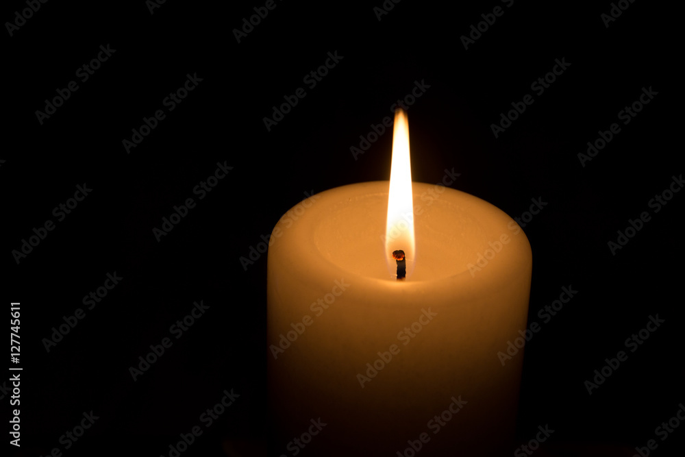 gelbe Kerze brennt im Dunkeln Stock-Foto | Adobe Stock
