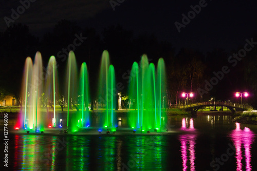 colored fountain in evening park in summer