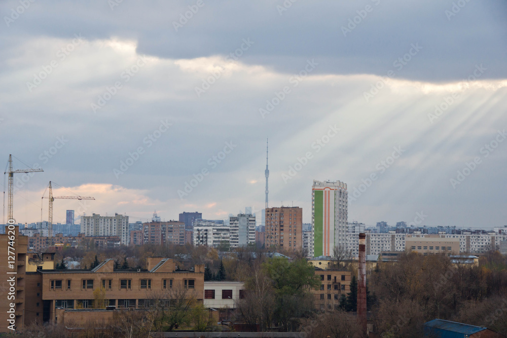 Sun rays in clouds above the city