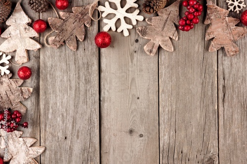 Rustic Christmas corner border with wood ornaments and berries on an aged wood background