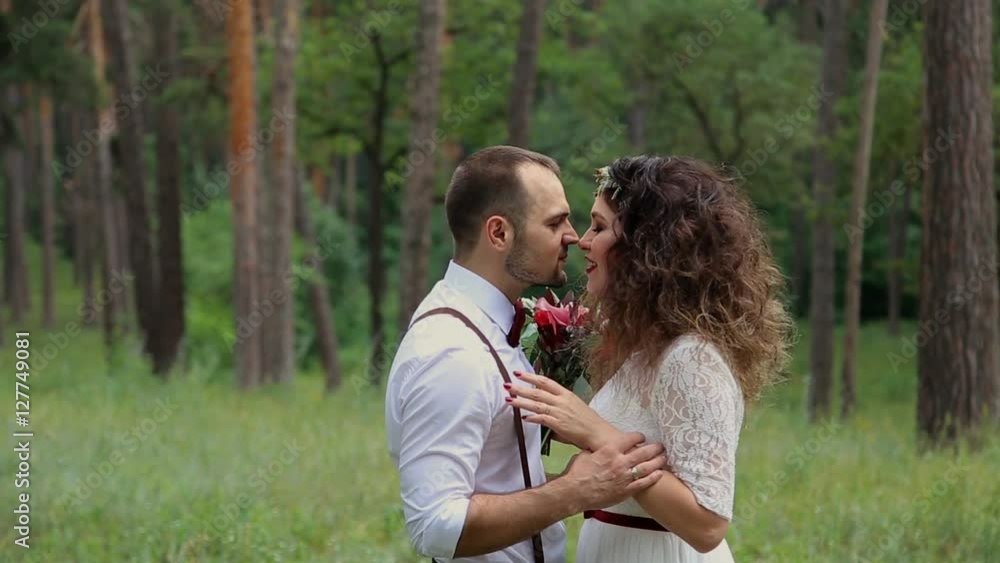Beautiful young couple in Bohemian style fashion in the forest. Looking into each other's eyes. Smile. Beautiful young couple in Bohemian style fashion in the forest. Looking into each other's eyes. Smile.
