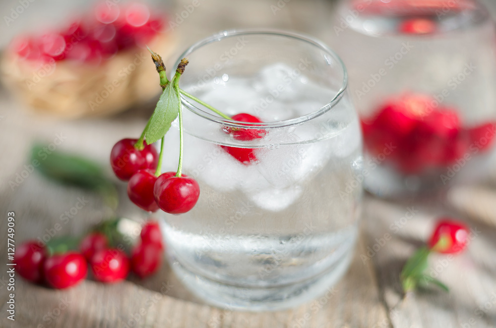 Cold water with ice and cherries. Selective focus. Cold water with ice and cherries. Selective focus.