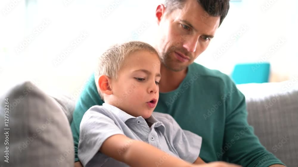 Father and son reading story book together Father and son reading story book together