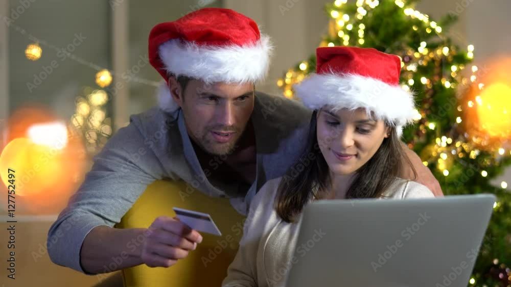 Couple buying Christmas gifts online with laptop Couple buying Christmas gifts online with laptop