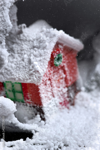 Miniature Christmas house in crushed ball all in Snow everywhere .Seelctive focus.Closeup