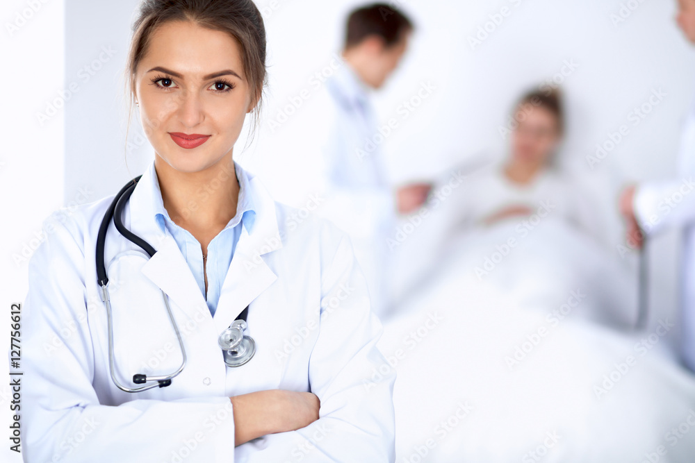 Female doctor smiling on the background with patient in the bed Female doctor smiling on the background with patient in the bed