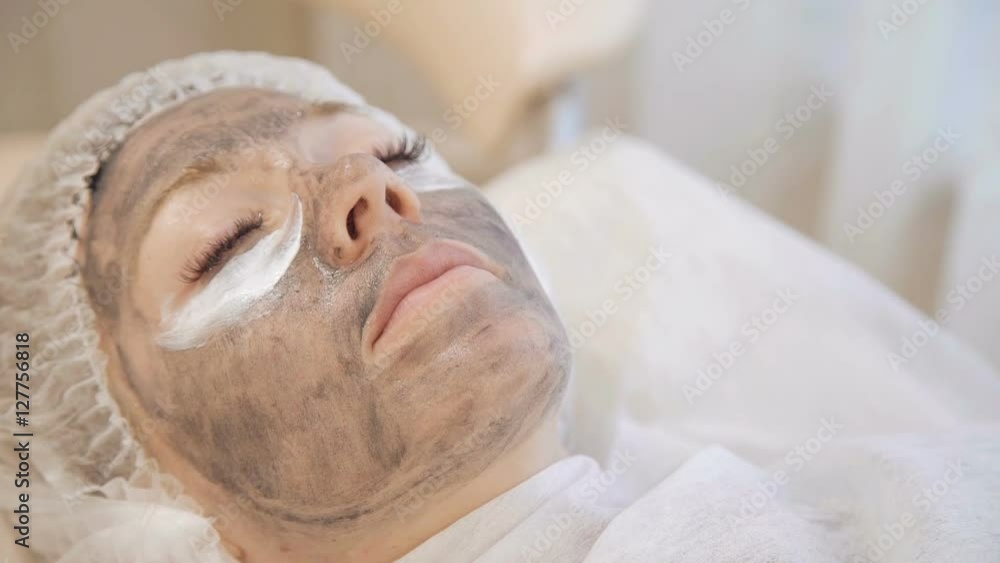 Applying marine mug mask on female face Applying marine mug mask on female face