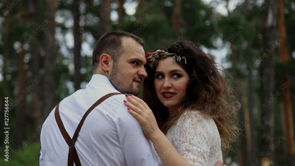 Stylish and luxurious the bride and groom looking back. Sitting in the woods. Stylish and luxurious the bride and groom looking back. Sitting in the woods.