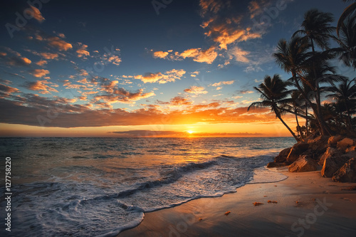 Sunrise on a tropical island. Palm trees on sandy beach.