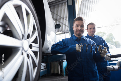 Cheeful mechanic reparing car